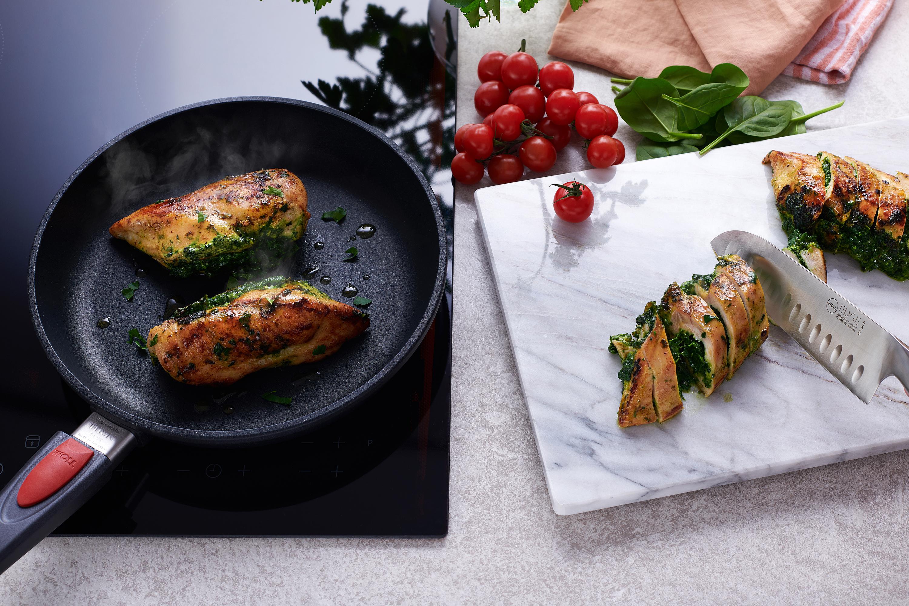 In einer runder Titan Best Pfanne werden Fleischrollen angebraten Daneben wird eine Fleischrolle auf einem Schneidebrett in Portionsgröße geschnitten.