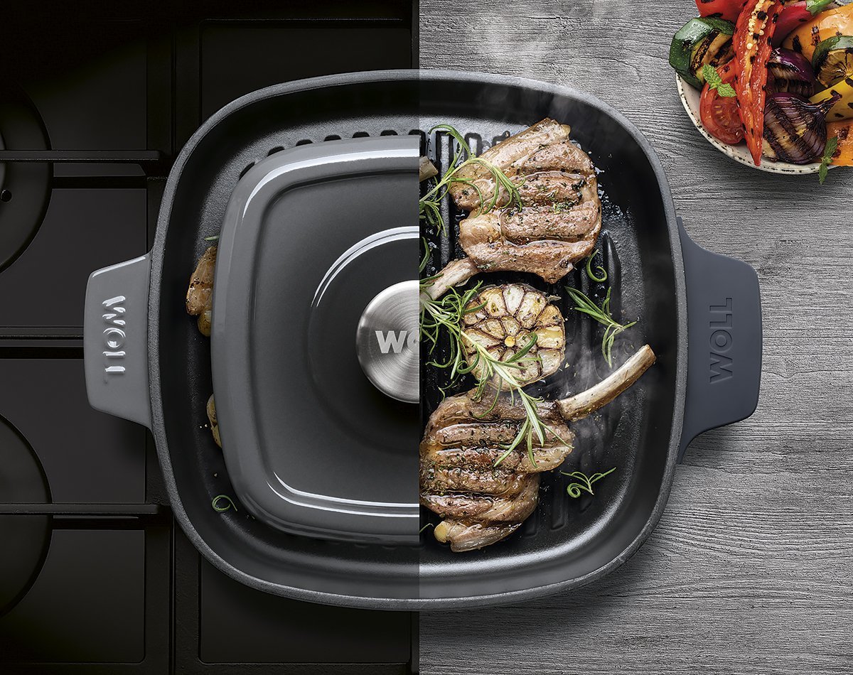 Die viereckige, graue Iron Grillpfanne mit Rillen und Steakpresse steht auf dem Herd und kann direkt mit dem angebratenen Fleisch auf den Tisch gestellt werden.