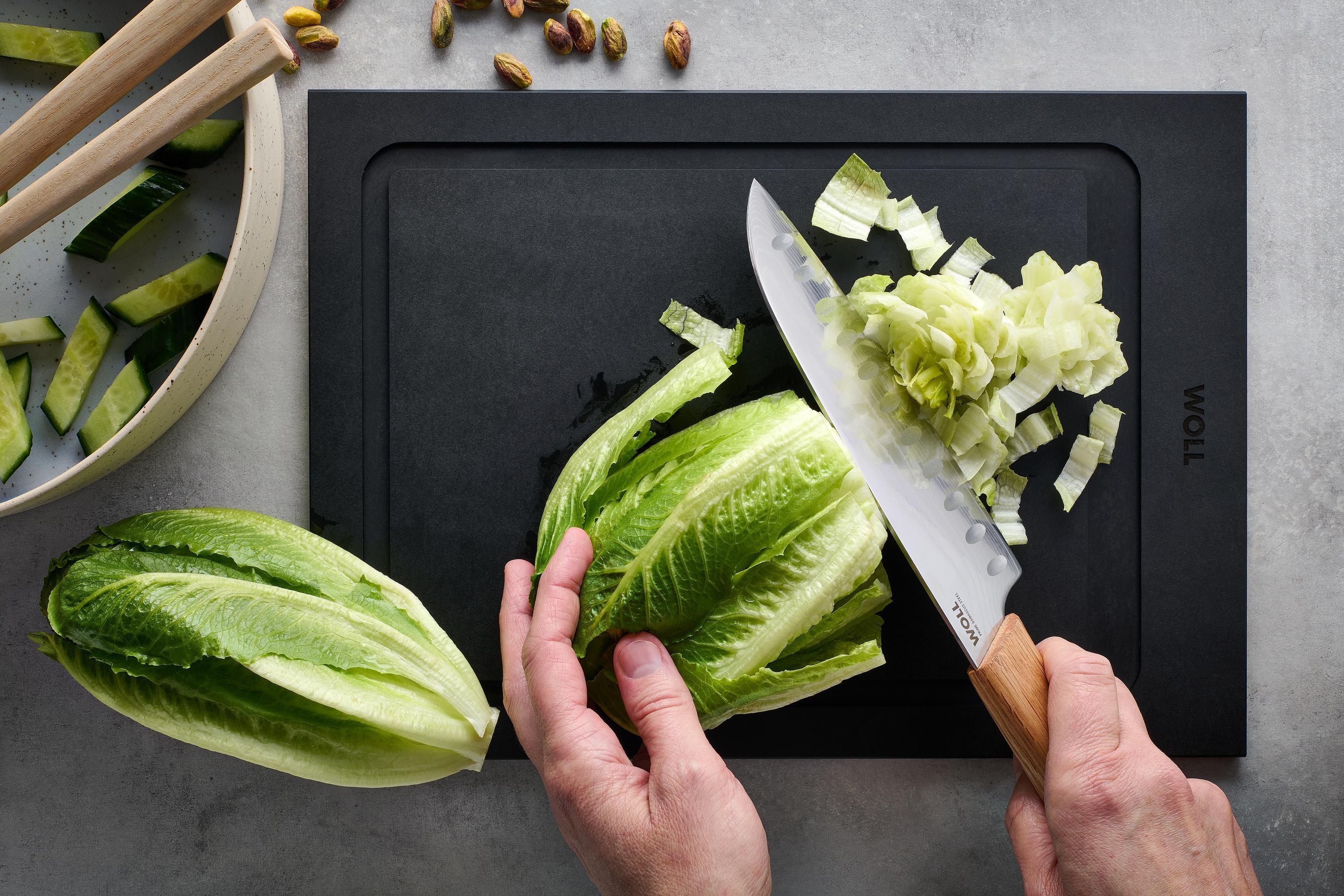 Mit dem Prime Edge Santokumesser wird ein Salatkopf auf einem Schneidebrett kleingeschnitten. 