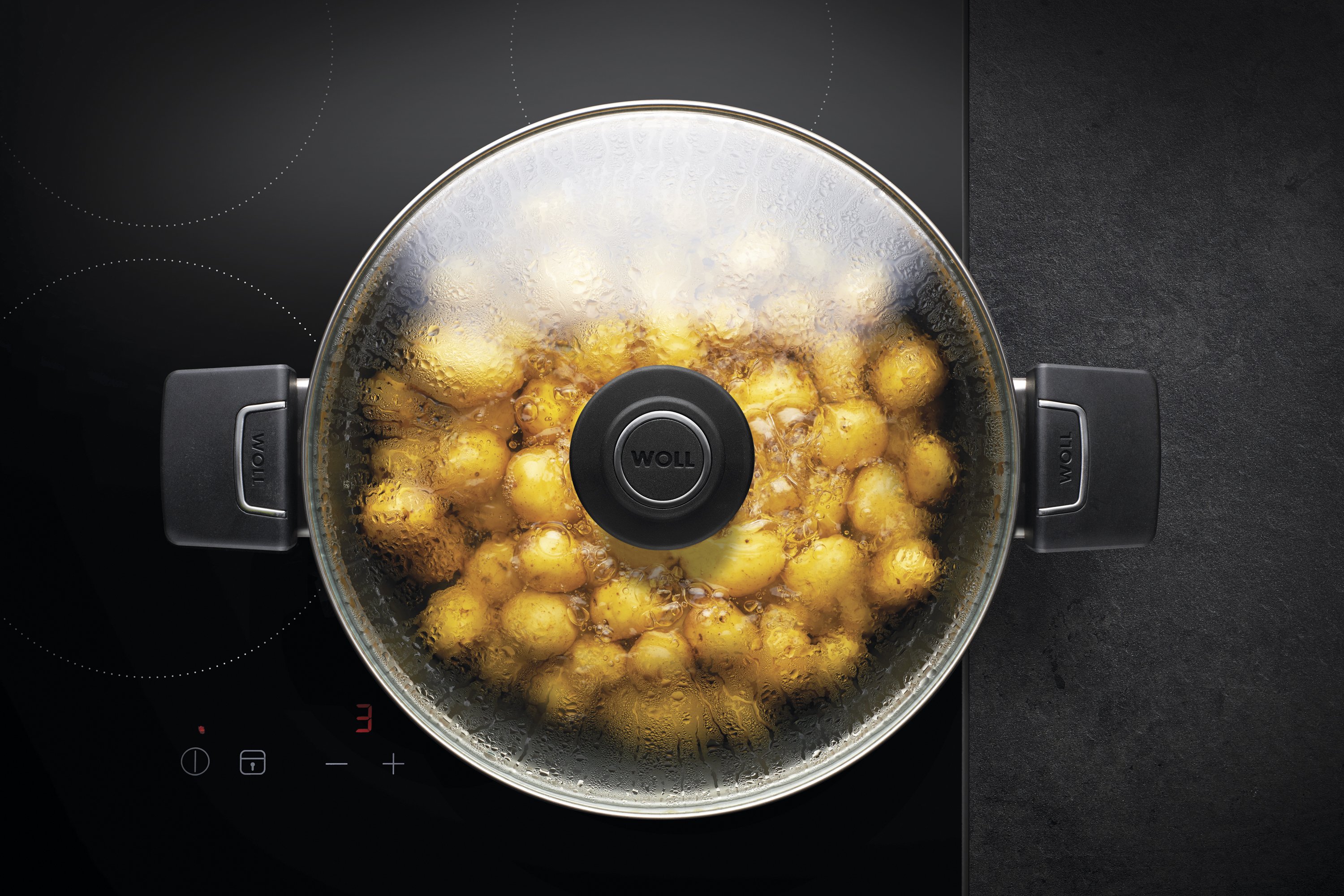 Auf dem Herd steht ein runder Diamond Lite Topf, in der sich ein dampfendes Gericht befindet. Am Glasdeckel hat sich Kondenswasser gebildet.