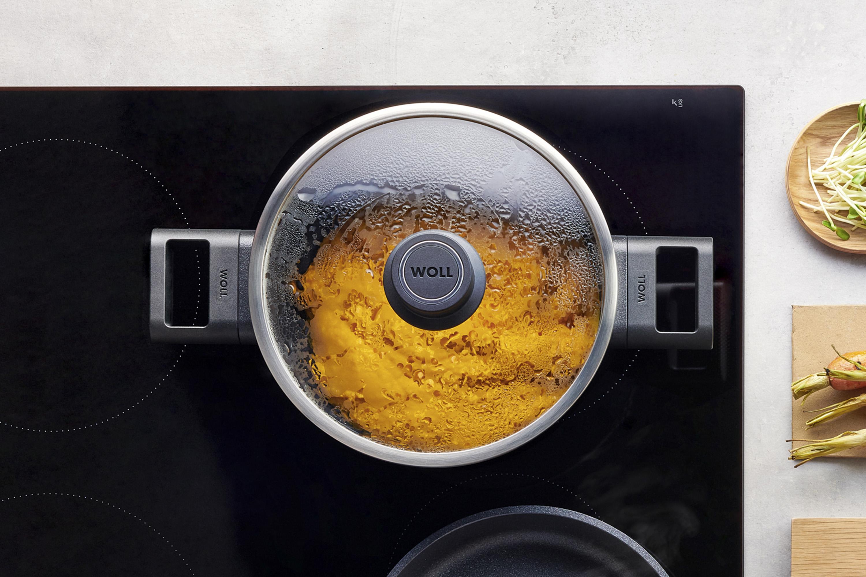 Auf dem Herd steht ein runder Topf der Serie Eco Logic QXR, in dem sich ein dampfendes Gericht befindet. Am Glasdeckel hat sich Kondenswasser gebildet.