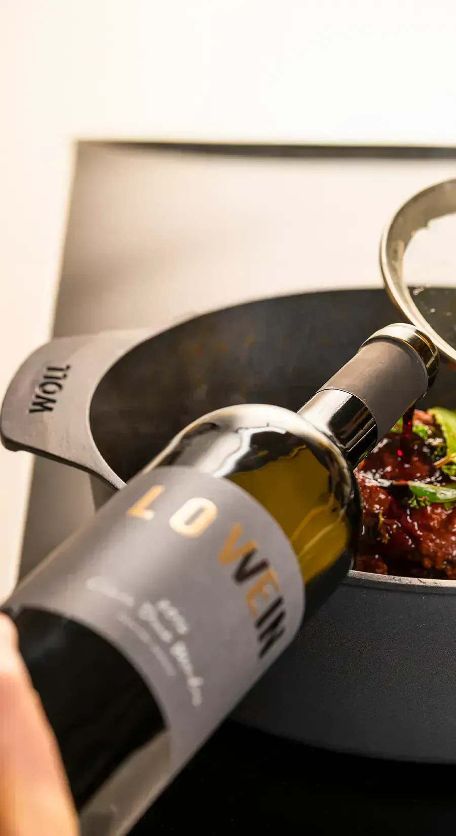 Ein heißer Bräter der Serie Diamond Lite enthält ein Gericht. Dieses wird mit Rotwein übergossen.