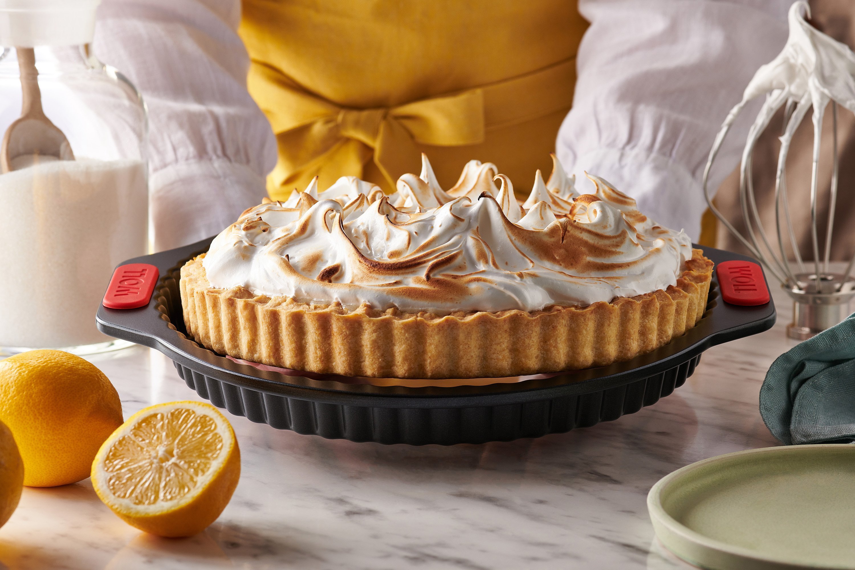 Eine Zitronen Baiser Torte wird aus der Let's bake! Quiche- und Tarteform wird mithilfe eines Hebeboden gelöst.