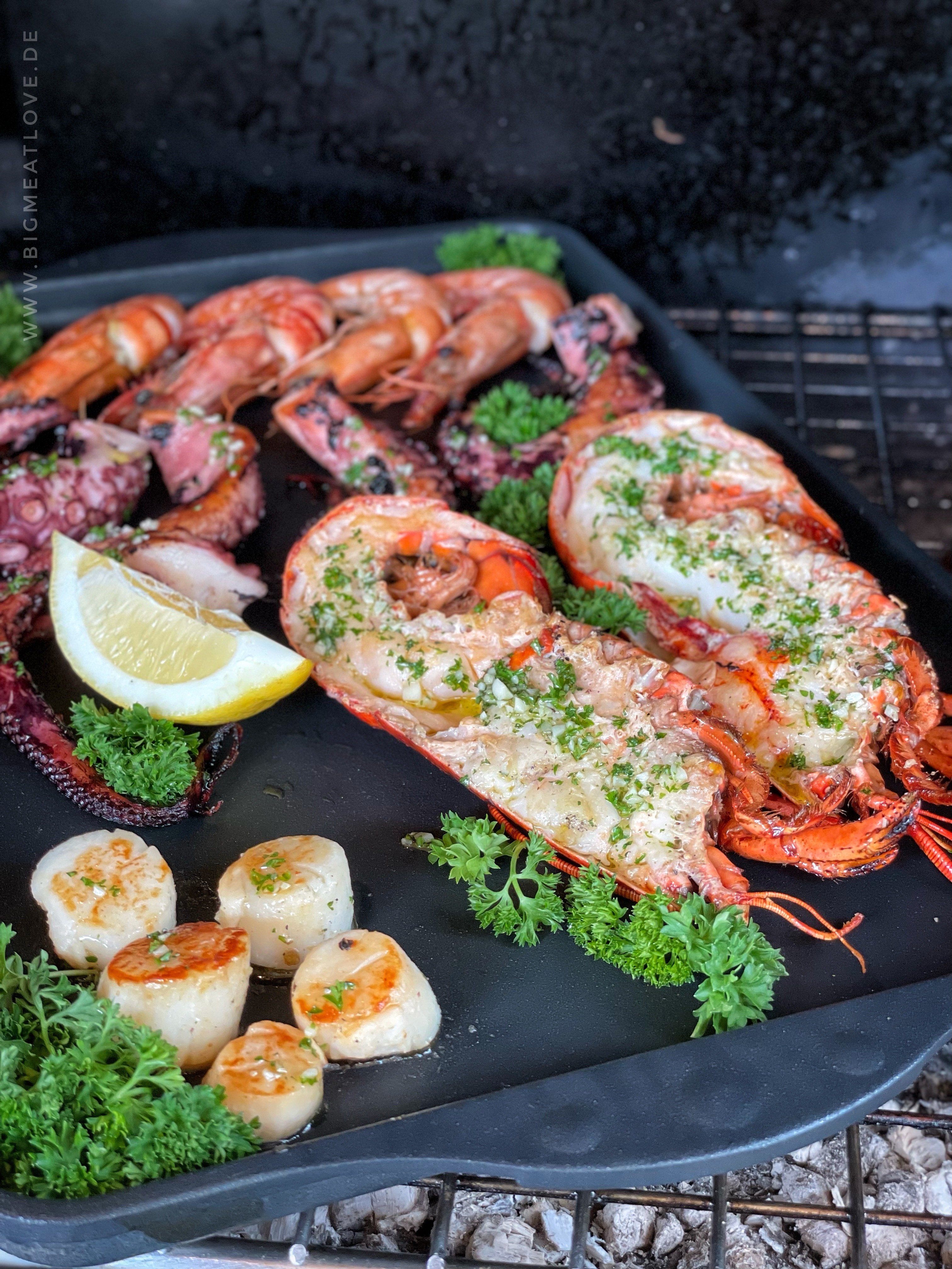 Auf dem Grill steht eine Titan Best Grillplatte / Teppan-Yaki- Platte, auf dieser werden Meeresfrüchte gegrillt. 