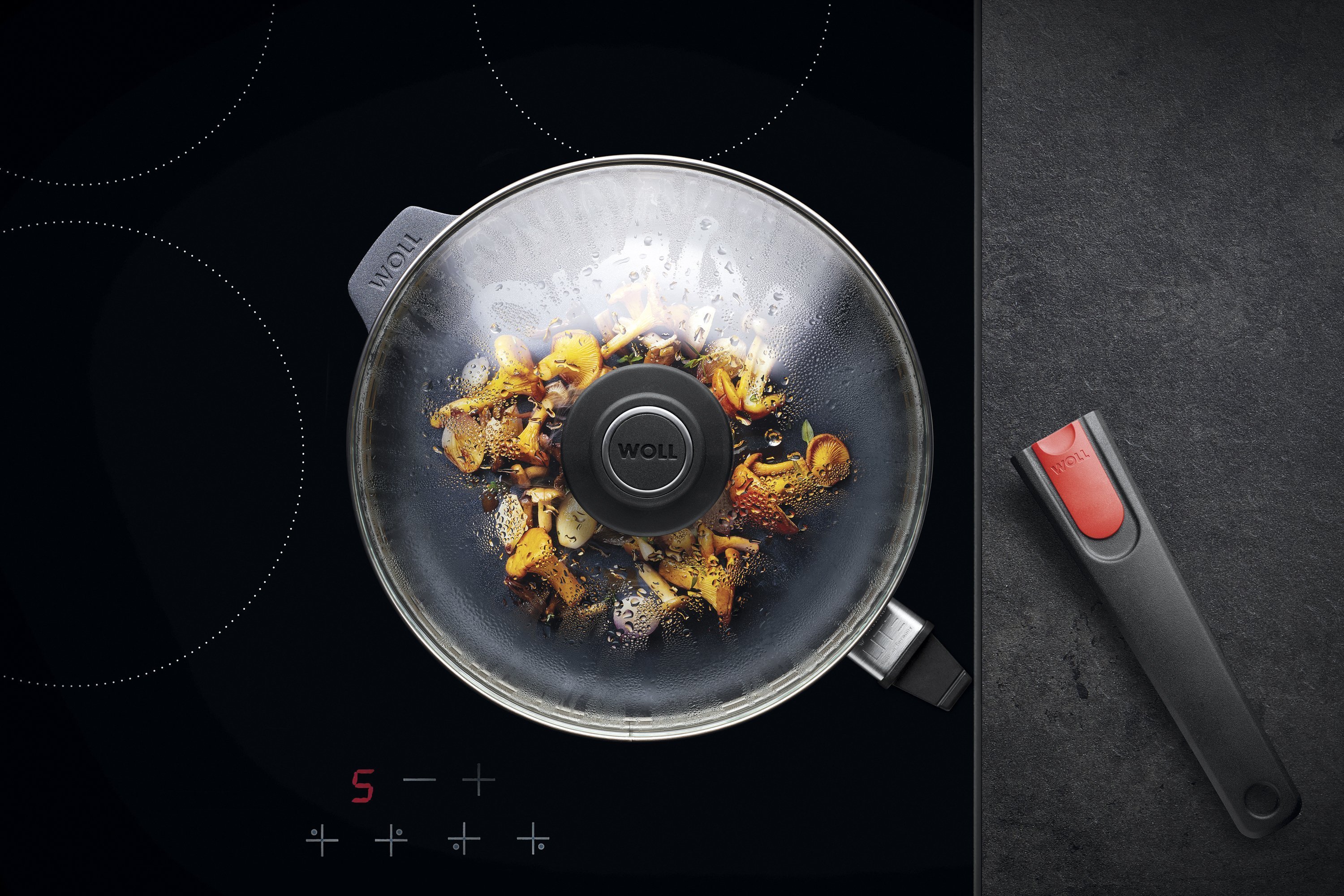 Auf dem Herd steht eine runde Diamond-Lite-Pfanne mit abgenommenem Stiel, in der ein Gericht zubereitet wird. Am Glasdeckel hat sich Kondenswasser gebildet.