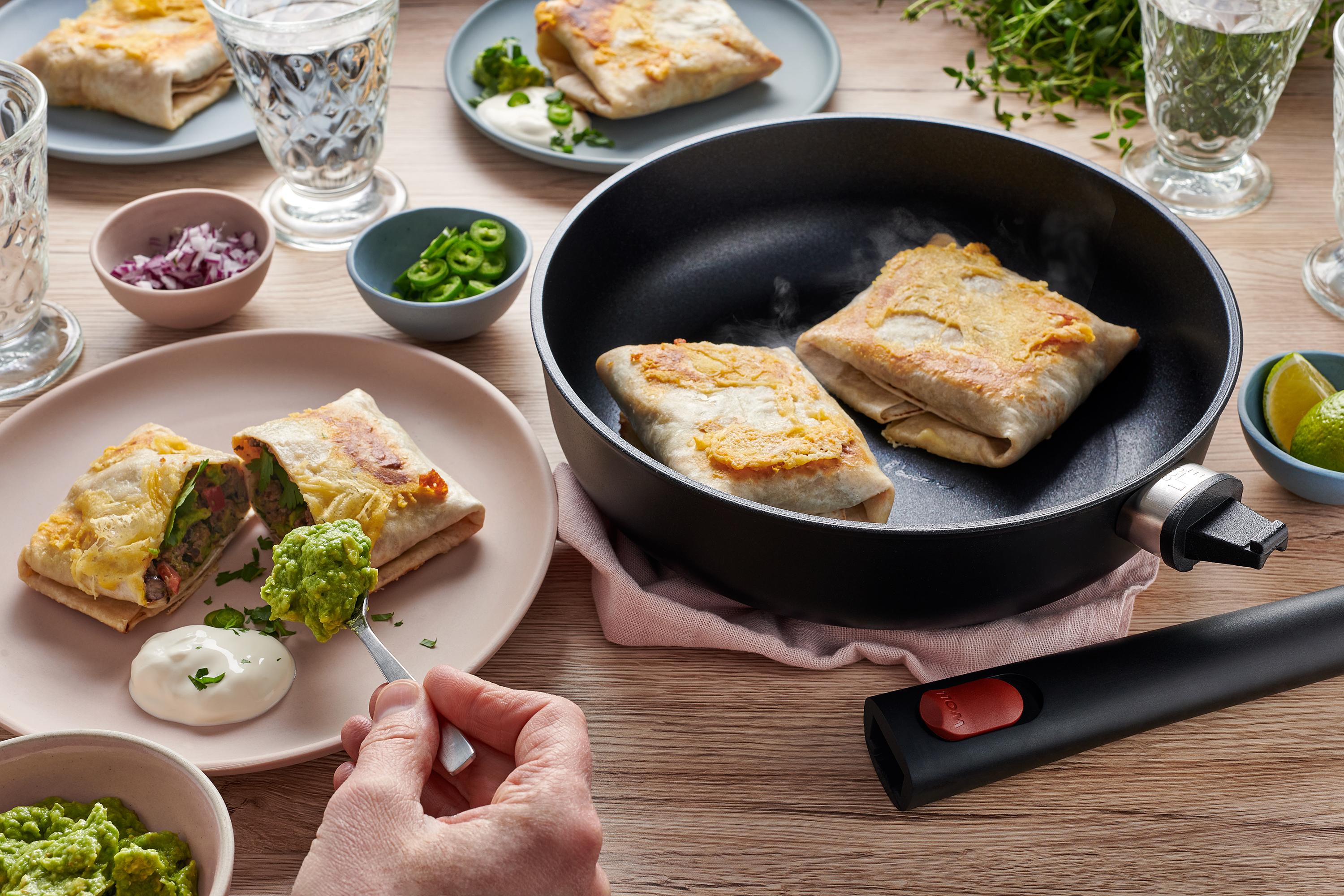 In einer runden Eco Lite QXR Pfanne werden Burritos angebraten und auf einem Teller platziert.