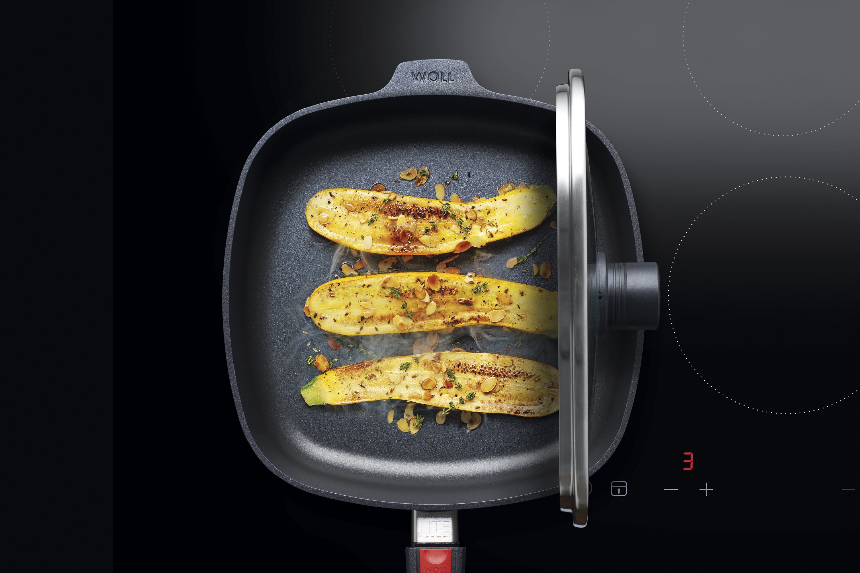 In einer viereckigen Diamond Lite Pfanne wird Gemüse angebraten. Der Smart Lid steht auf der Pfannenkante.